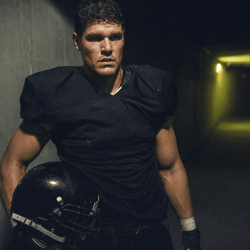 A NFL player in a floodlit stadium tunnel